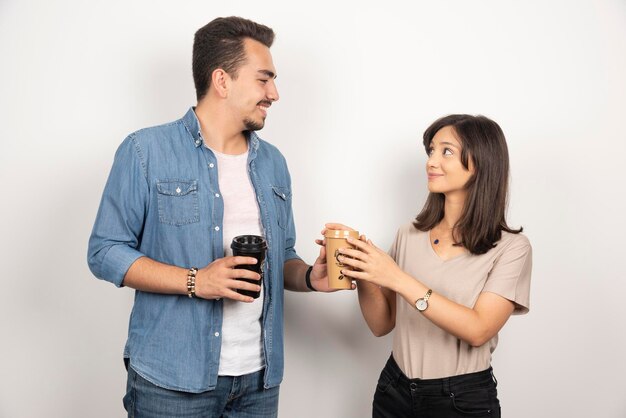 Young man giving a cup of coffee to young woman. 