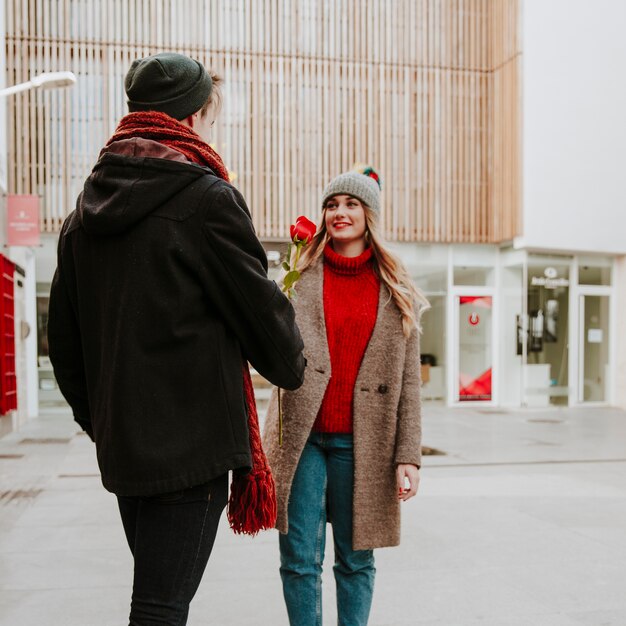 Young man giving rose to girlfriend