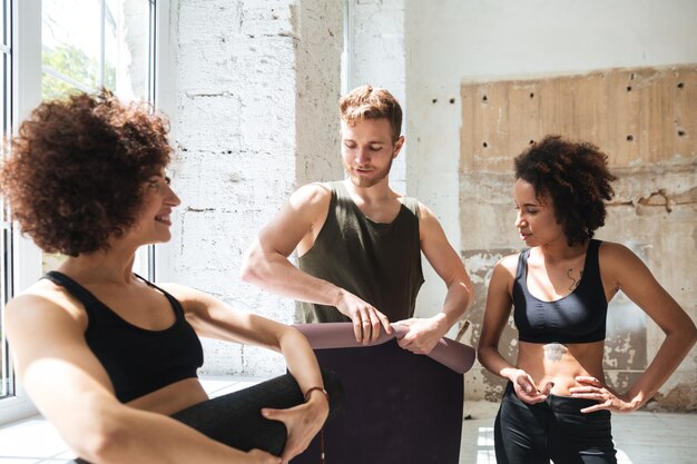 Young man giving training mat laughing woman