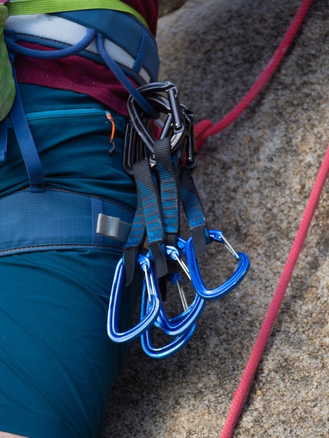 Free photo young man go to climb on the rock with quickdraws hanging of his harness