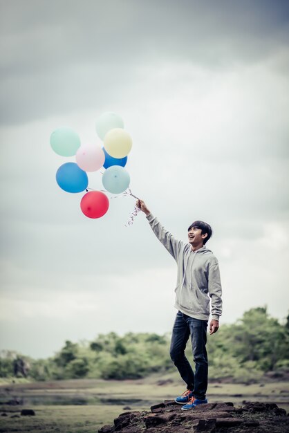 Молодой человек рука, проведение красочные воздушные шары