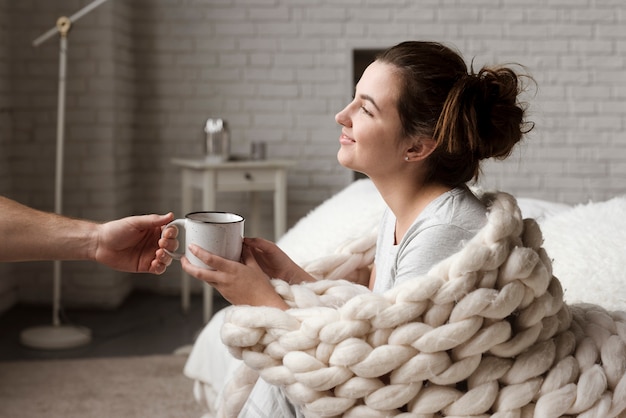 Young man handing cup of coffee to girlfriend