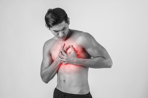 Young man has heart attack isolated on white background.