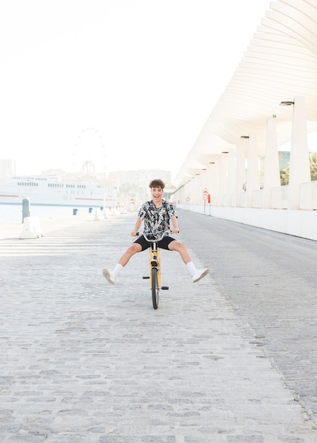 Young man having fun while riding bicycle