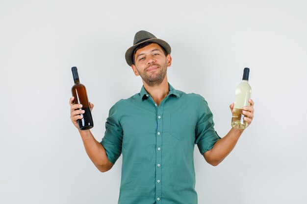Young man holding alcohol bottles in shirt
