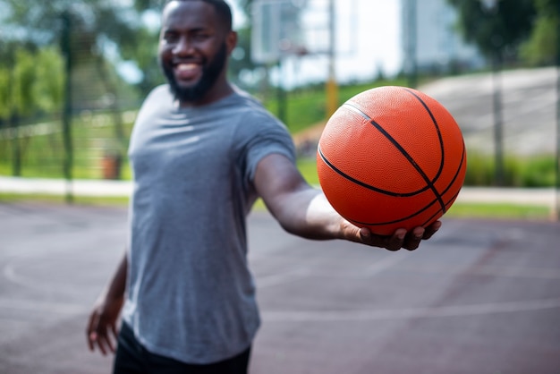 Young man holding a ball medium shot