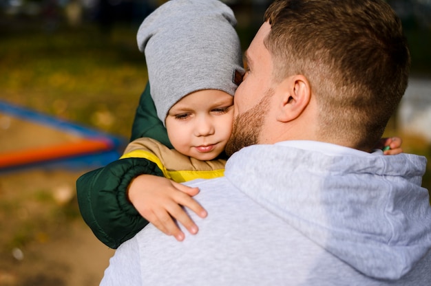 Young man holding a boy in his arms