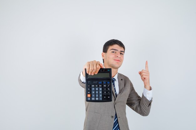 Young man holding calculator, raising index finger