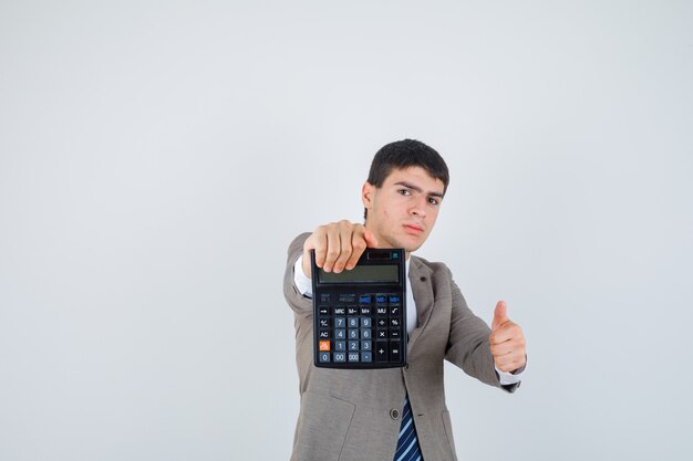 Young man holding calculator, showing thumb up in formal suit