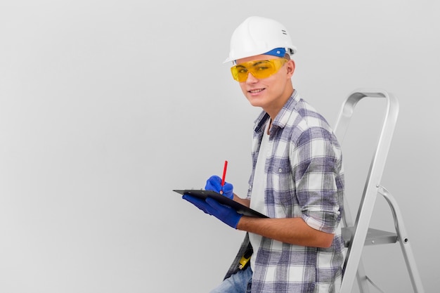 Young man holding clipboard on stairs