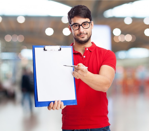 Free photo young man holding a clipboard with a blank sheet