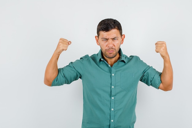 Young man holding fists up in shirt and looking nervous