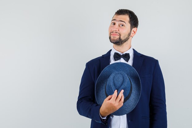 スーツに帽子をかぶって、陽気に見える若い男、正面図。