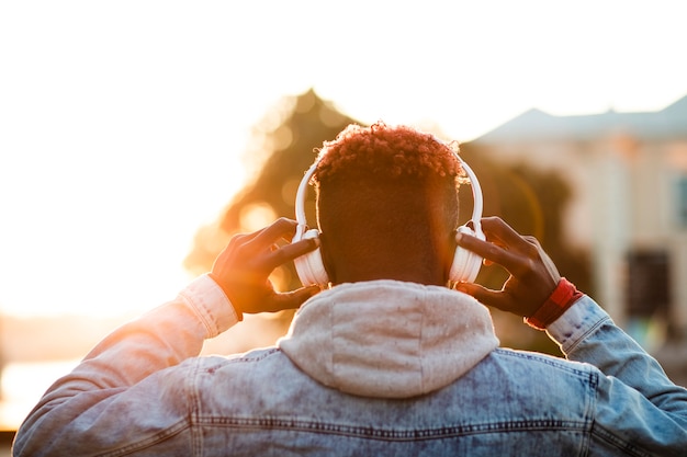 Young man holding headphones on head