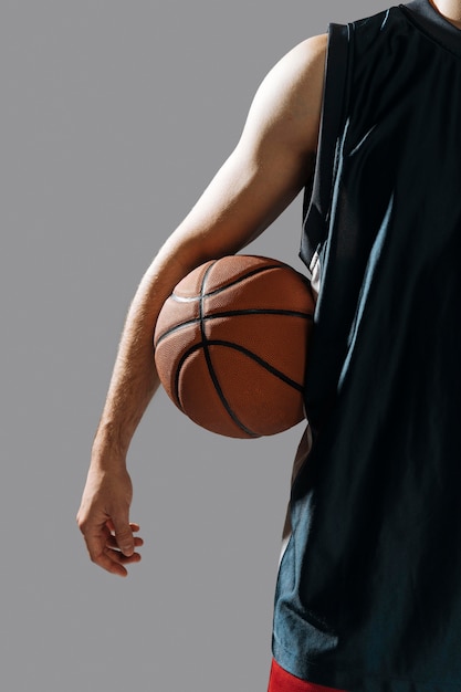 Бесплатное фото Молодой человек держит свой баскетбол