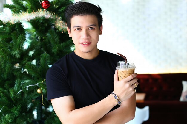 Young man holding iced coffee