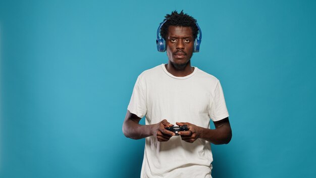 Young man holding joystick to play video games on console