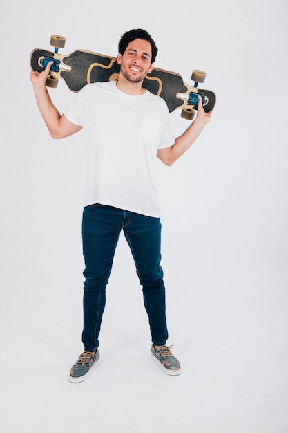Young man holding longboard behind neck