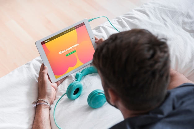 Young man holding modern device with spotify app