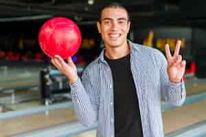 Free photo young man holding a red bowling ball