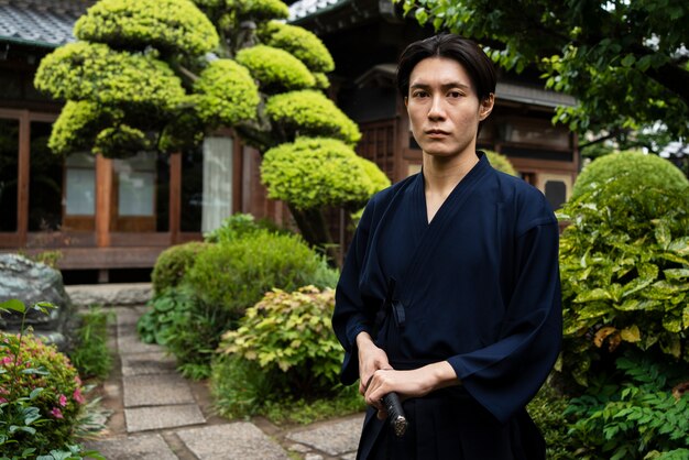 Young man holding samurai sword side view