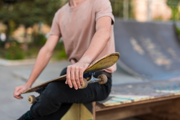 Foto gratuita giovane che tiene uno skateboard