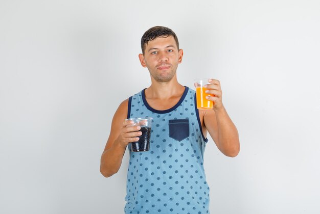 Молодой человек держит безалкогольные напитки в синей майке