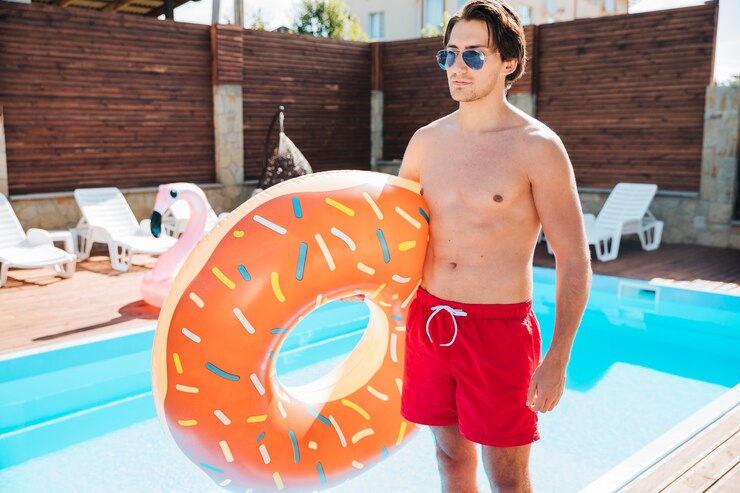 Free Photo young man holding a swim ring