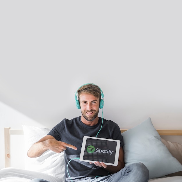 Young man holding tablet with spotify app