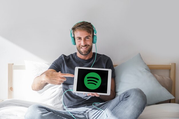 Young man holding tablet with spotify app