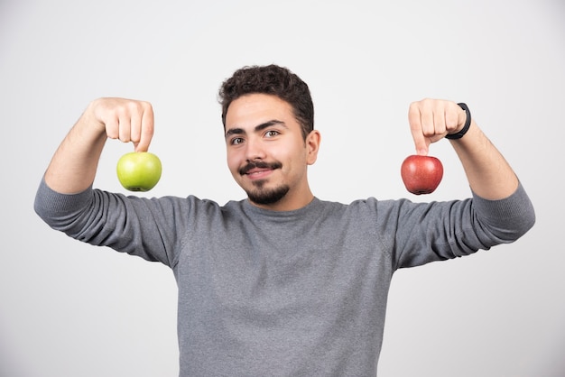 회색에 두 개의 사과 들고 젊은 남자.