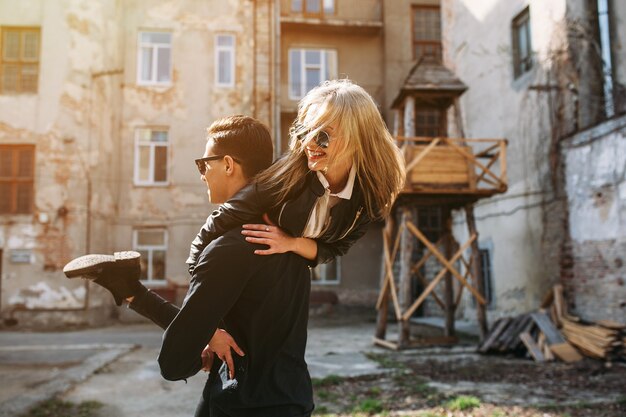 Young man holds his beautiful girl on hands