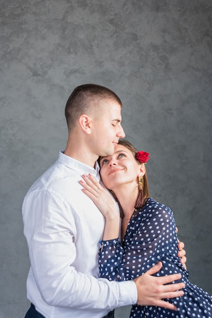 Young man hugging woman in blue dress