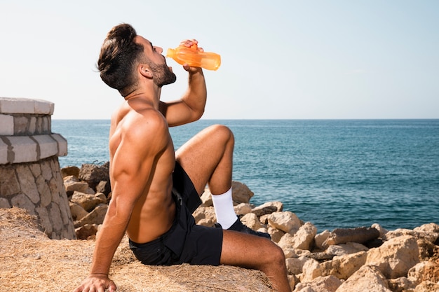 Young man hydrating after exercising