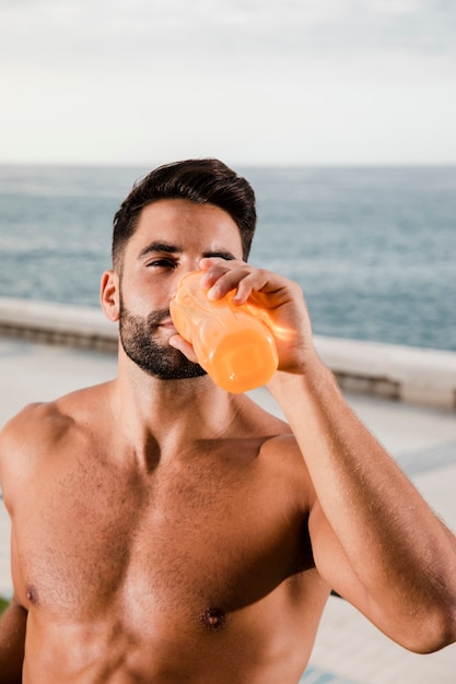 Young man hydrating after outdoor training