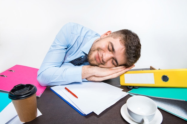 The young man is brazenly sleeping on the desktop during his working hours