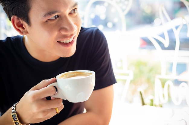 The young man is happy to drink coffee