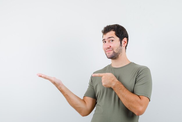 The young man is pointing to left with his forefinger on white background