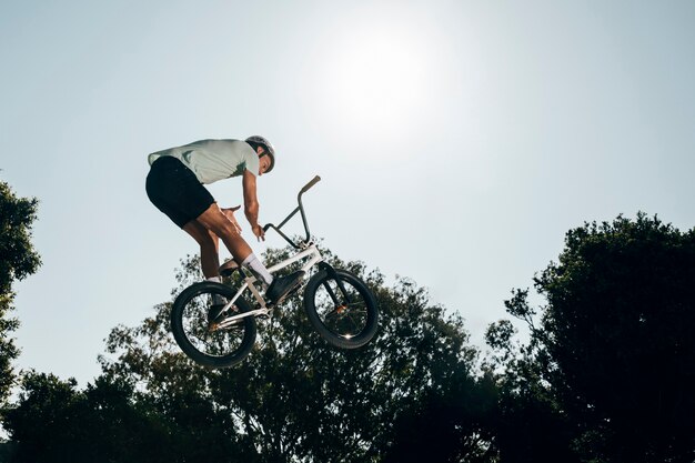 Young man jumping with bicycle up high 