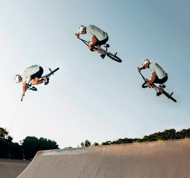 Young man jumping with bmx bike at the skate park