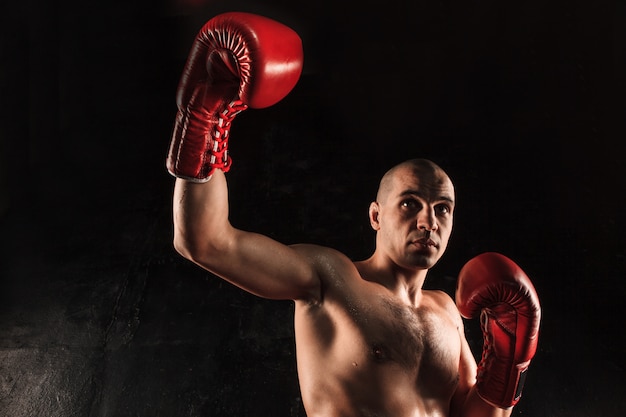 young man kickboxing on black