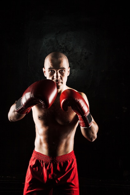 The young man kickboxing on black