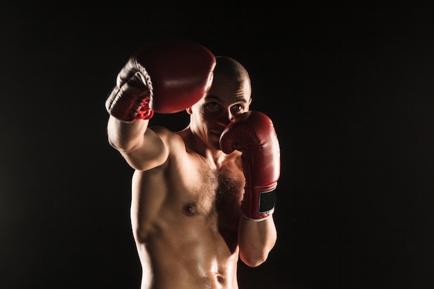 The young man kickboxing in blue smoke