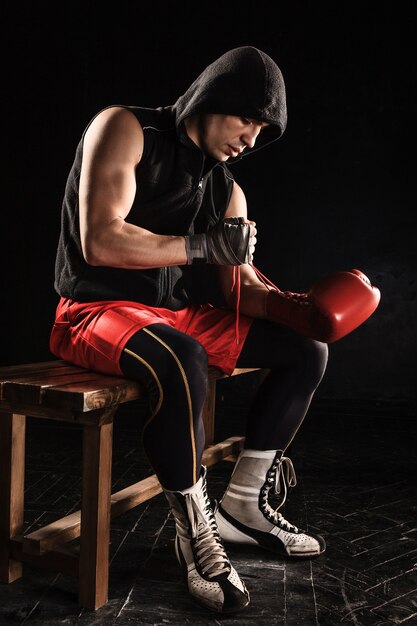 The young  man kickboxing lacing glove