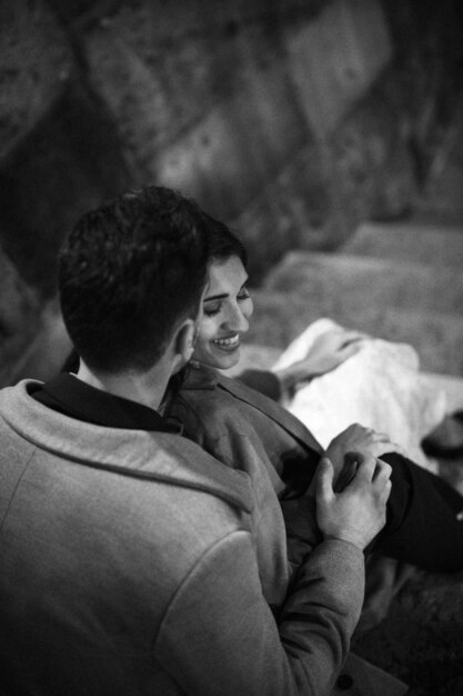 Young man kissing happy woman on steps 