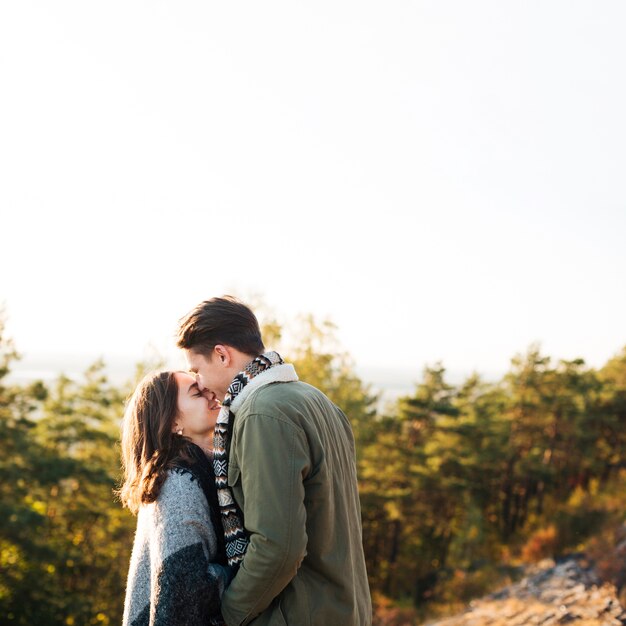 Young man kissing his girl in the nature