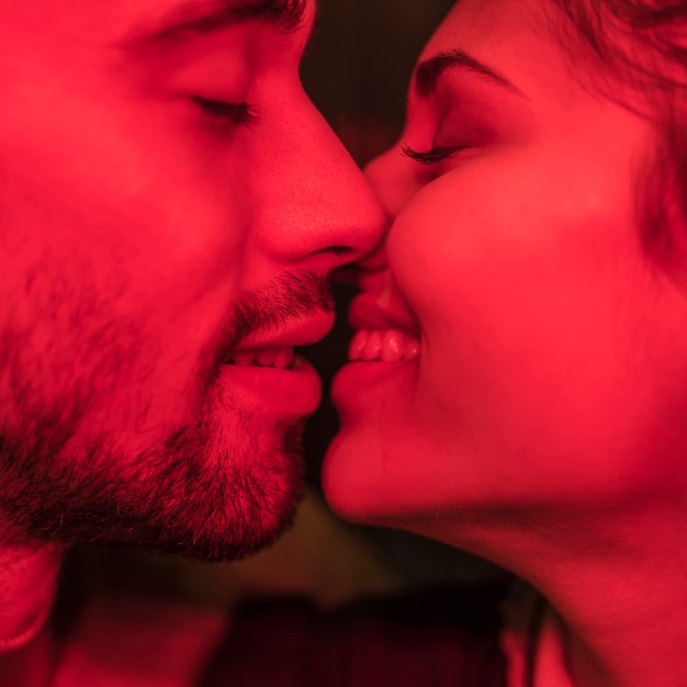 Young man kissing smiling woman