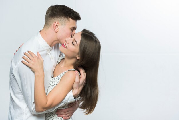 Young man kissing woman on cheek 