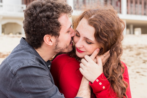 Young man kissing woman on cheek 