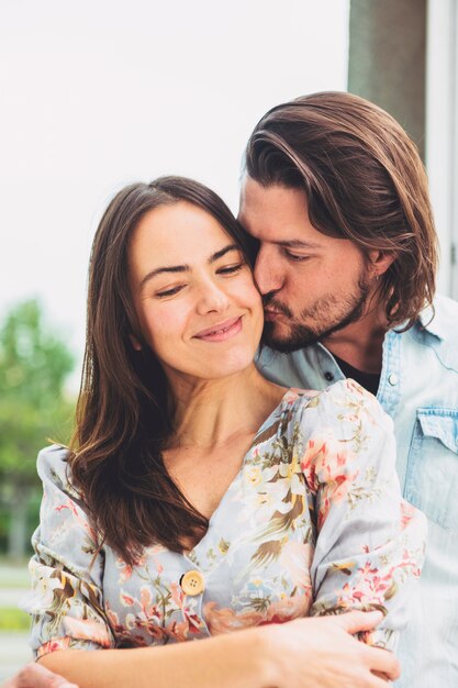 Young man kissing woman on cheek 